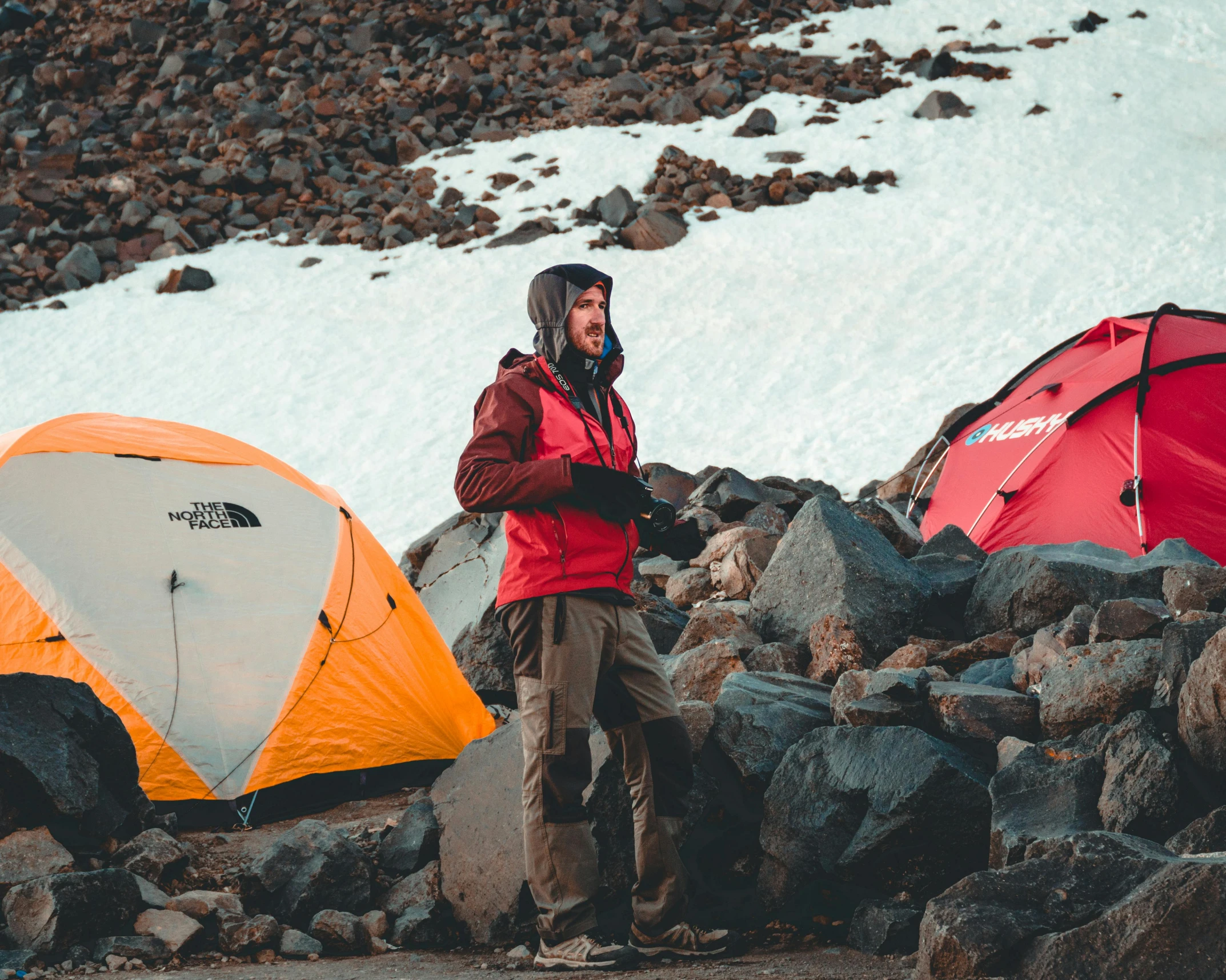 a man standing next to a couple of tents, trending on unsplash, avatar image, extreme sports, extremely high resolution, volcanic