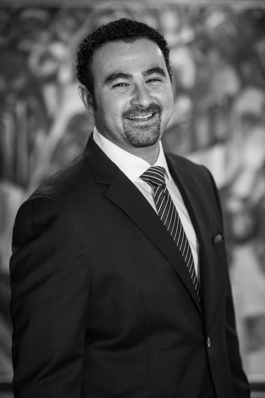 a man in a suit smiling while posing for the camera