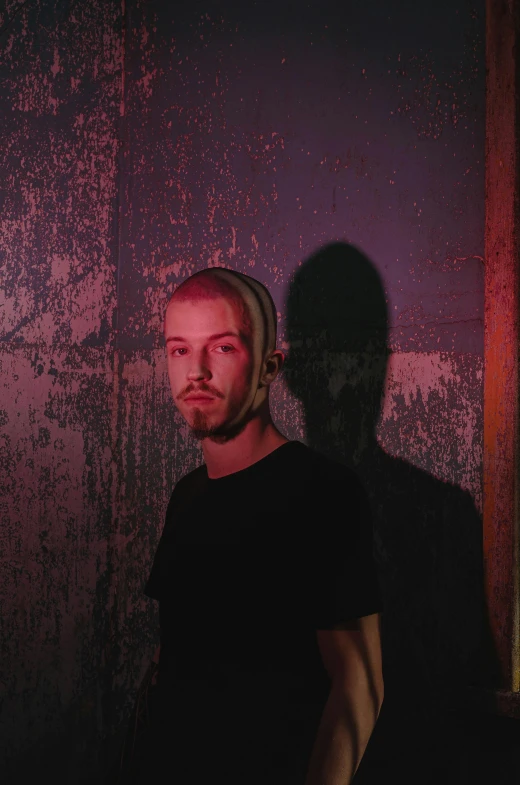 a young man in the dark stares at the camera