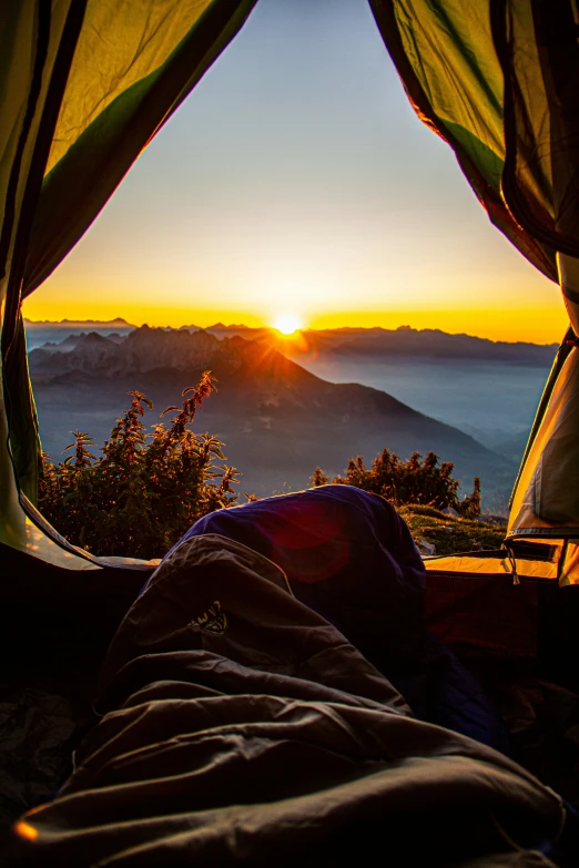 a person laying in a tent with the sun setting, by Sebastian Spreng, pexels contest winner, overlooking a valley, in the swiss alps, laying in bed, looking onto the horizon