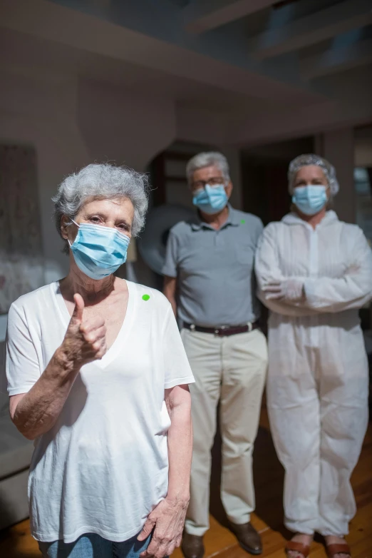a group of people wearing face masks in a room, a portrait, older woman, thumbs up, paul barson, coronavirus
