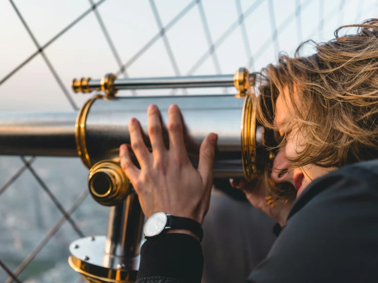 a close up of a person looking through a telescope, trending on unsplash, romanticism, empire state building, on the deck of a sailing ship, holding gold watch, an young urban explorer woman