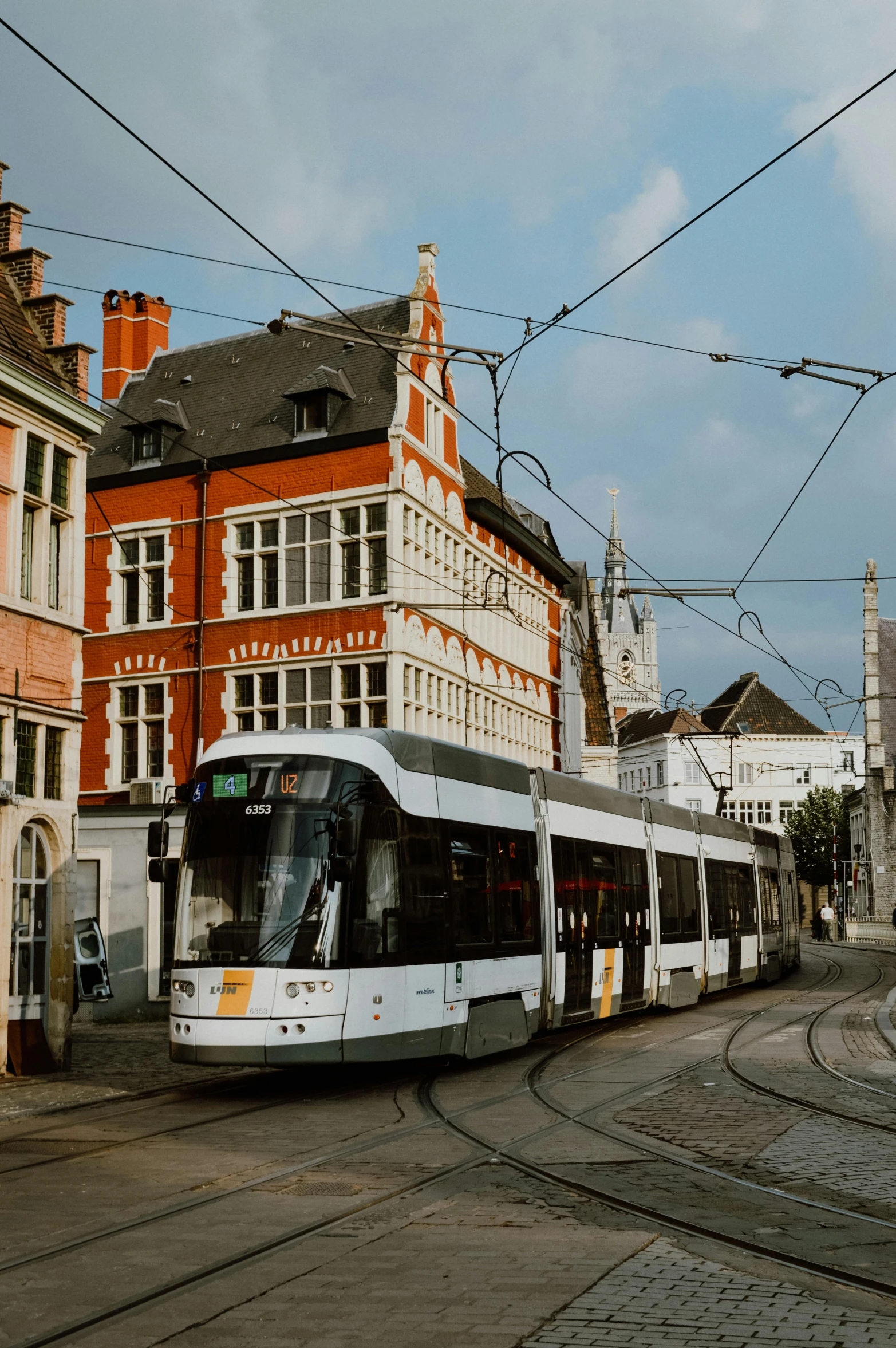 a modern tram on an inner street with buildings