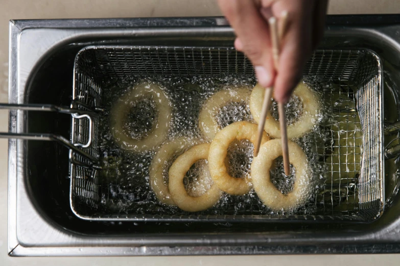 a person frying doughnuts in a deep fryer, inspired by Nishida Shun'ei, trending on unsplash, hurufiyya, epicurious, 2000s photo, mint, apple