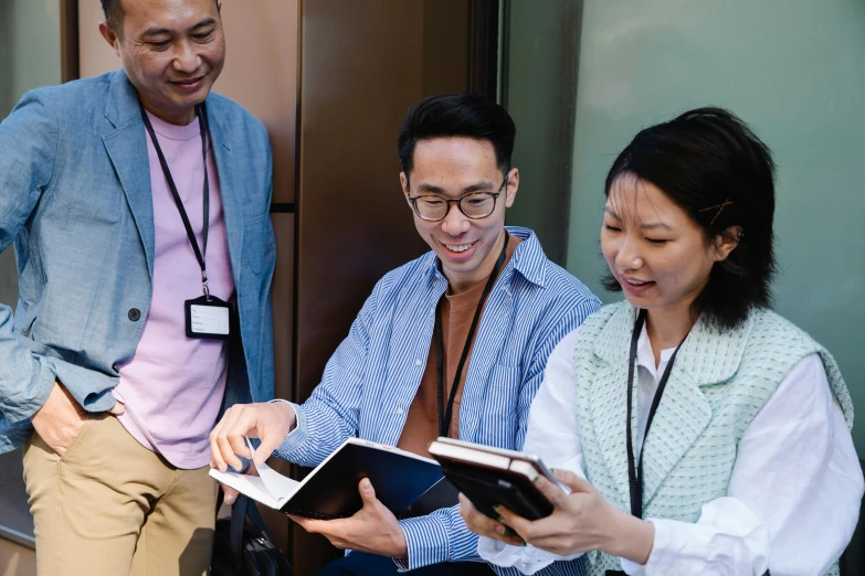 a group of three people standing next to each other, pexels contest winner, happening, holding notebook, asian features, dialogue, thumbnail