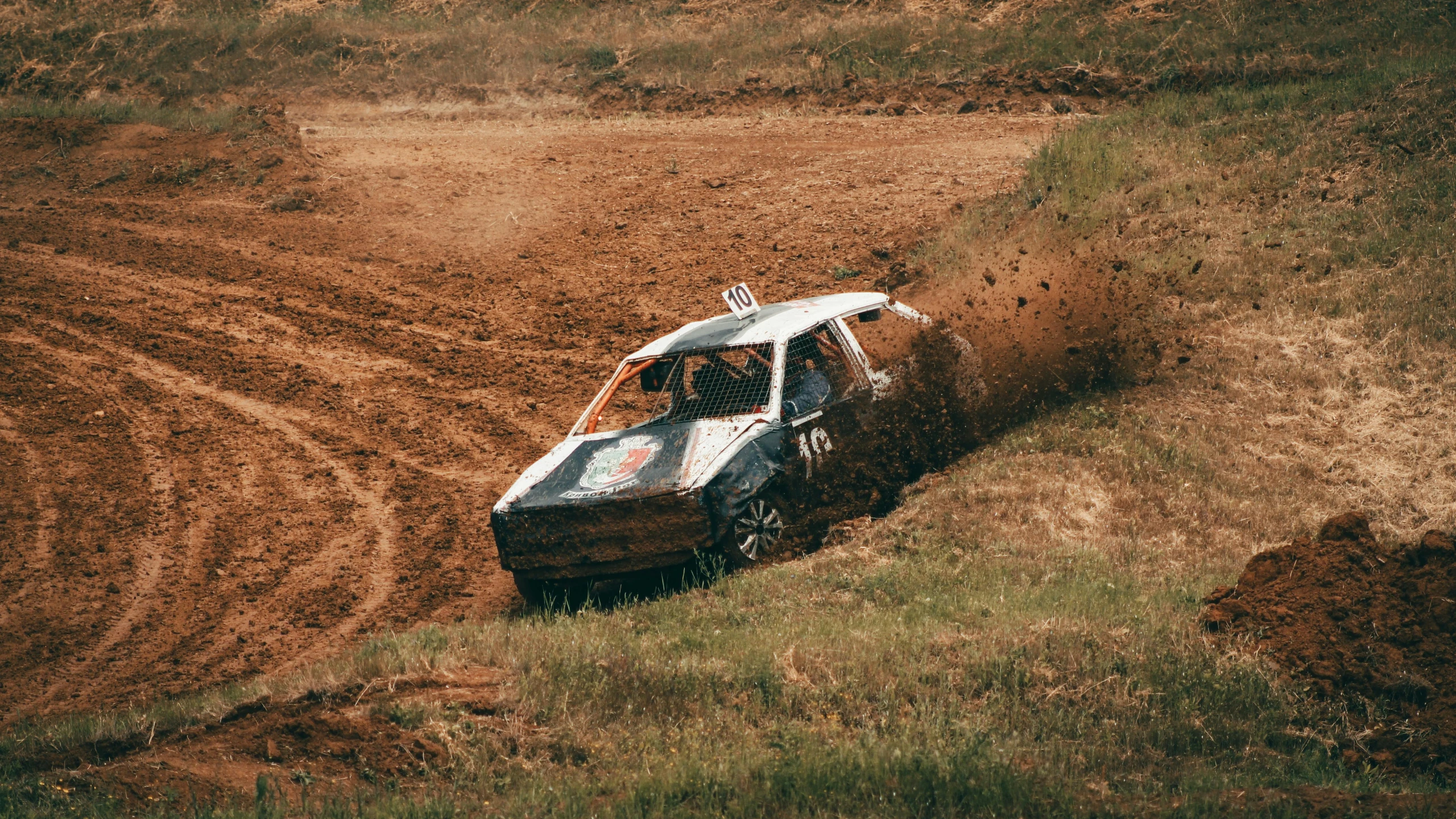 the jeep is driving down the dirt road