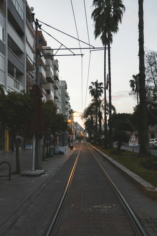 a railroad crossing a street in the evening