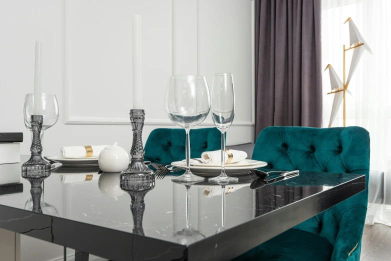 a glass table is set with place settings and empty wine glasses