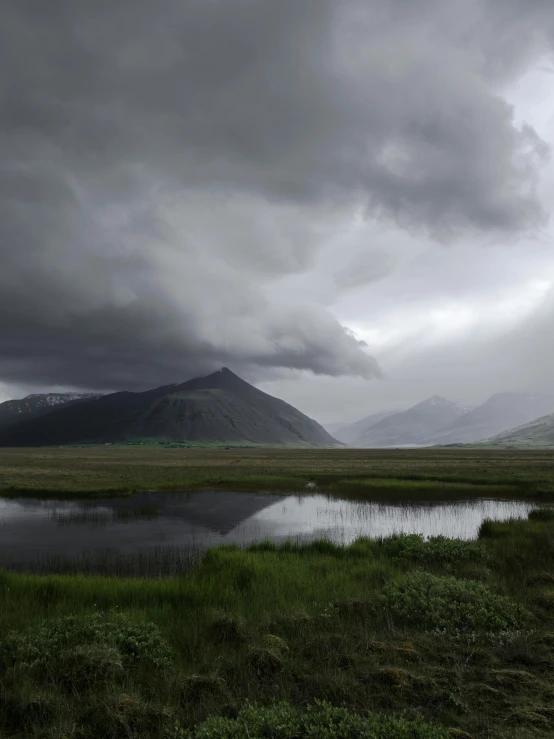 the rain is coming over the mountains behind water