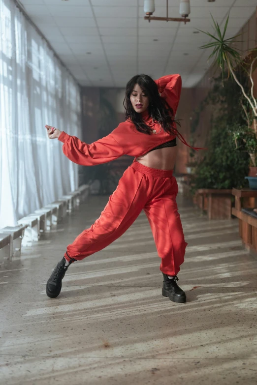 a woman dressed in orange doing a dance move