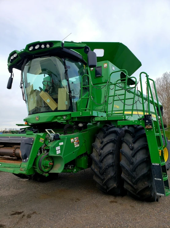a large green tractor parked in a parking lot, profile image, mechanical superstructure, outside in a farm, avatar image