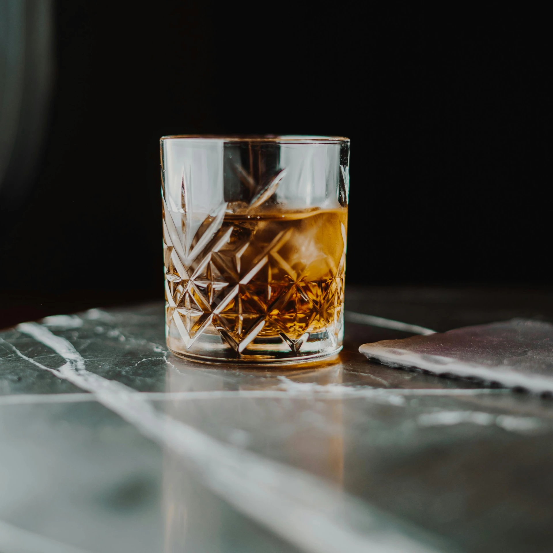 a glass of whiskey sitting on top of a table