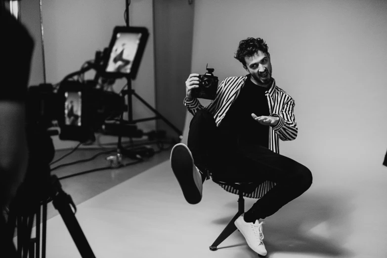 a man sitting on a chair in front of a camera, by Emma Andijewska, influencer, jay bauman, everyone having fun, romain jouandeau