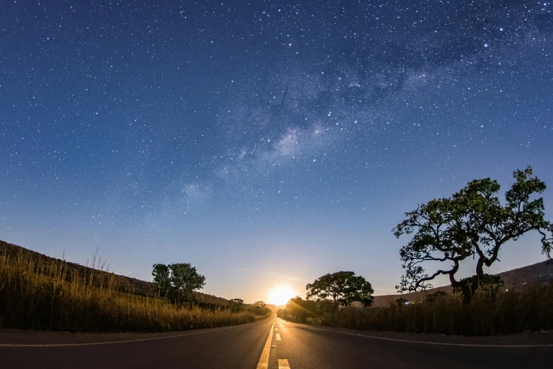 a road in the middle of a field under a sky full of stars, an album cover, unsplash contest winner, suns and supernovas, instagram post, big island, 500px