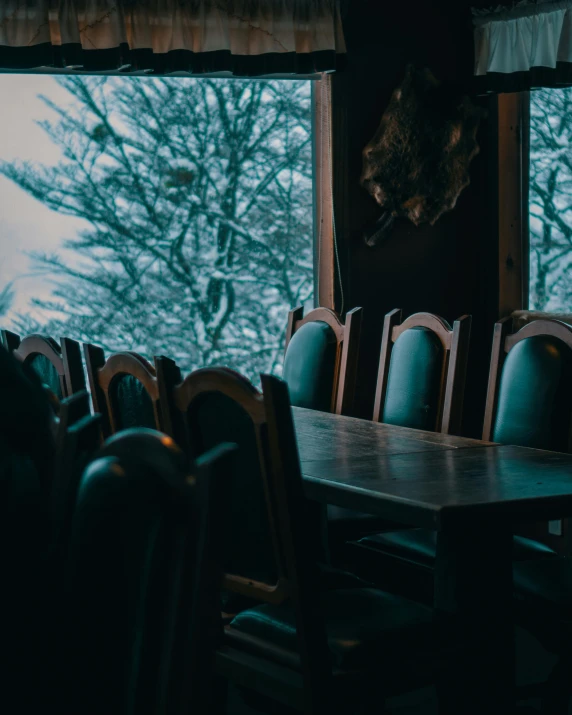 a table and chairs in front of a large window