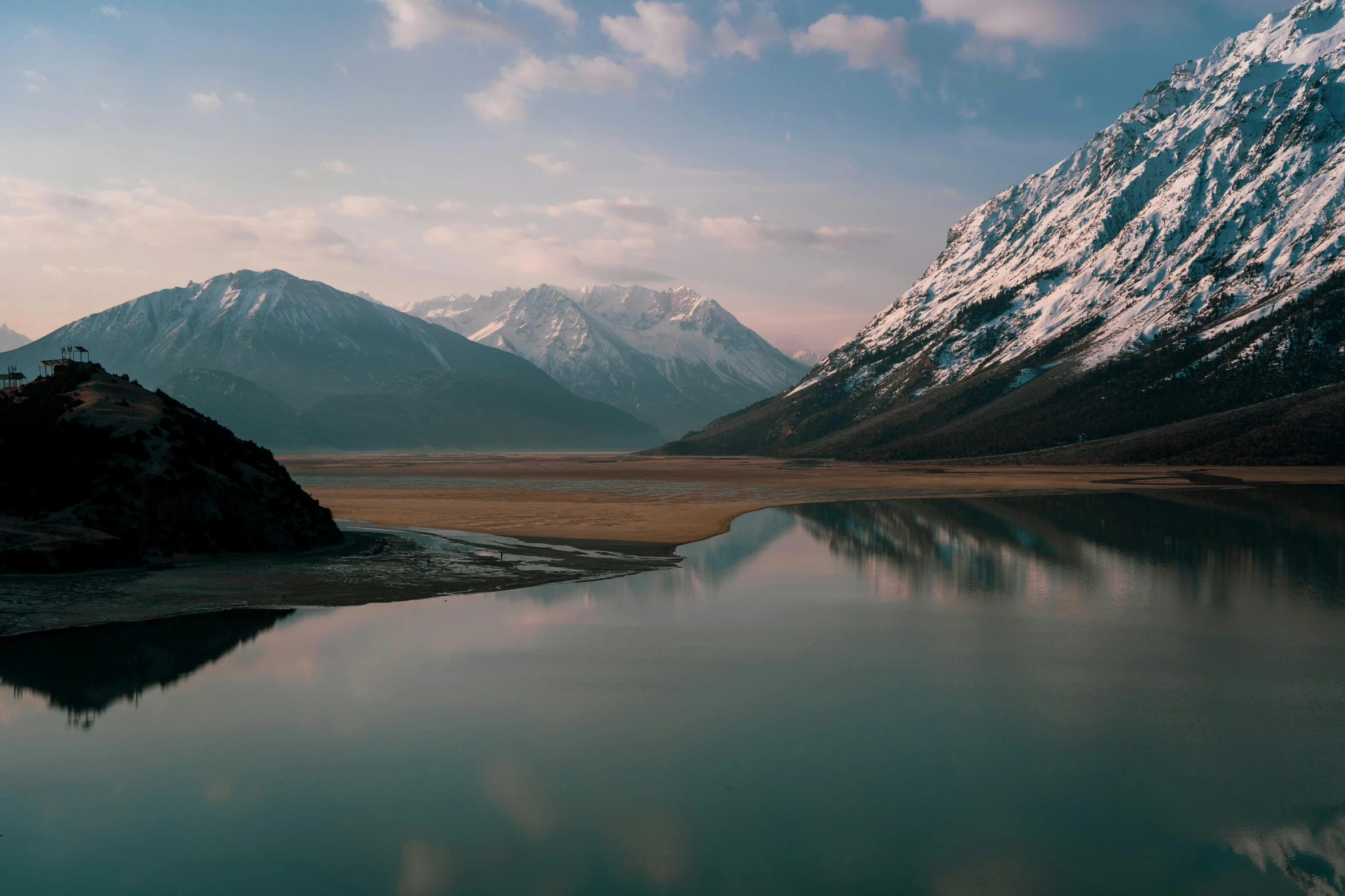 a mountain range is seen on the shore