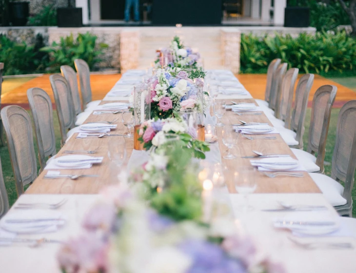 the long table is decorated with pink and purple flowers