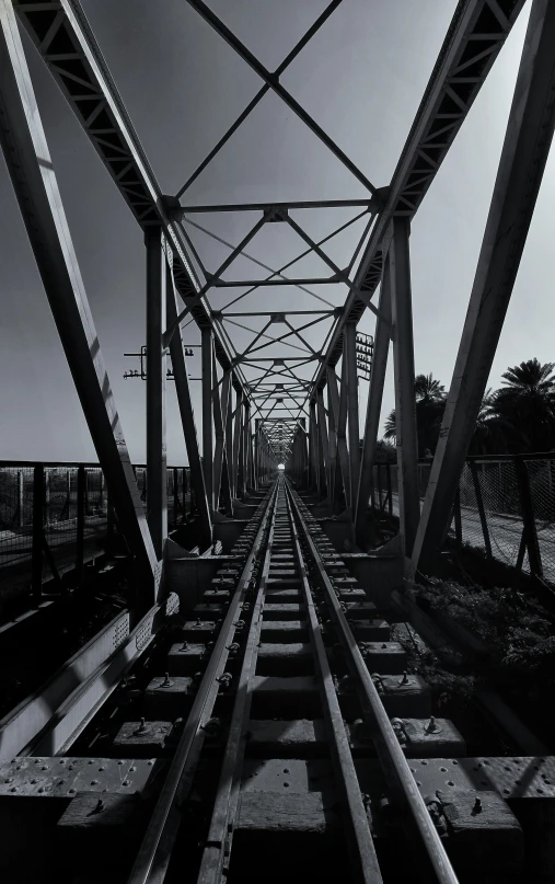 a black and white photo of a train track, by Byron Galvez, standing on a bridge, los angeles ca, view up, 1990s photograph