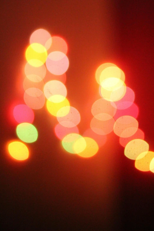 a blurry photo of some lights in the dark, by Peter Alexander Hay, pexels, lyrical abstraction, letters, red and yellow light, holiday, screensaver