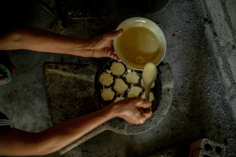 a close up of a person holding a bowl of food, process art, colombia, baking cookies, photograph credit: ap, thumbnail