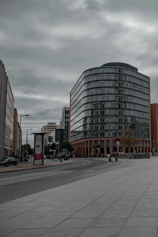 a city street with people walking around, next to a very tall building