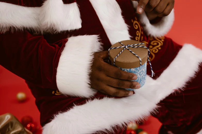 man dressed in santa claus suit holding a present box