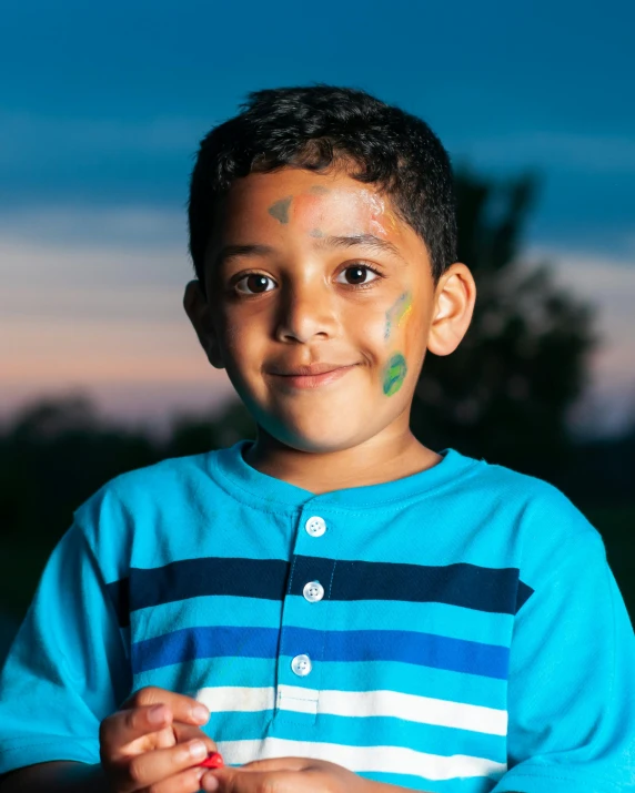 a little boy in striped shirt with face paint