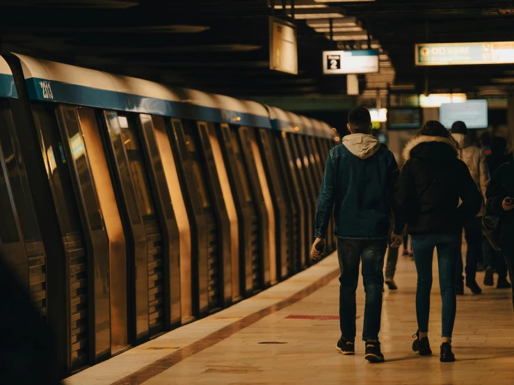 two people walking across the platform in the evening