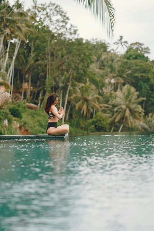 a woman sitting on top of a boat in a body of water, unsplash, sumatraism, next to a tropical pool, pond, couple, balance