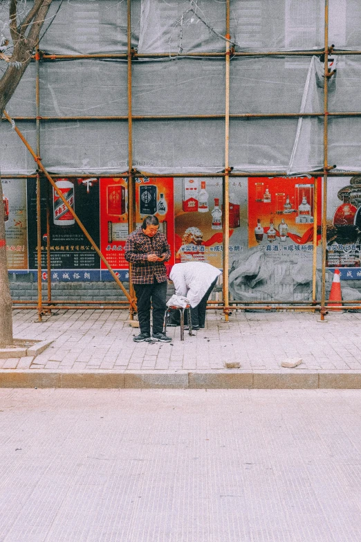 a po of people walking on the sidewalk, in front of a building