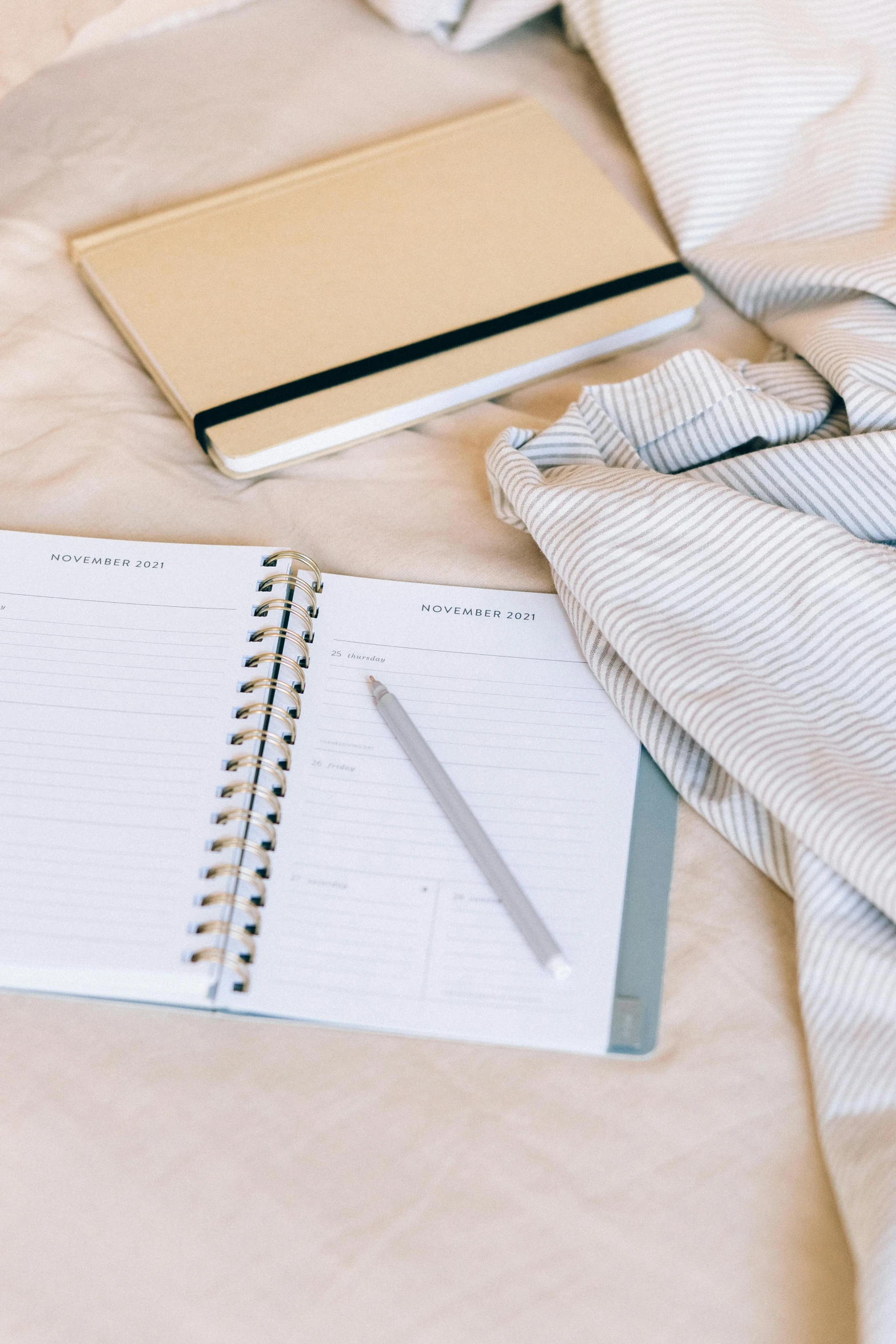 an open notebook sitting on top of a bed next to a cup of coffee, office clothes, thumbnail, organized, collection product