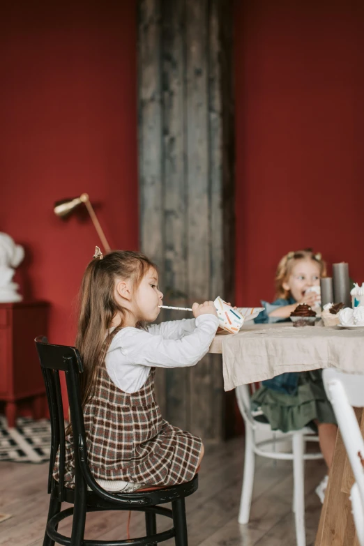 two little girls sitting at a table eating cake, by Adam Marczyński, pexels contest winner, fine art, drinking cough syrup, decoration, young girl playing flute, tabletop model