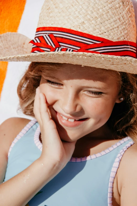 a little girl sitting on a beach chair wearing a straw hat, trending on pexels, beauty mark on cheek, slide show, super close up, panels