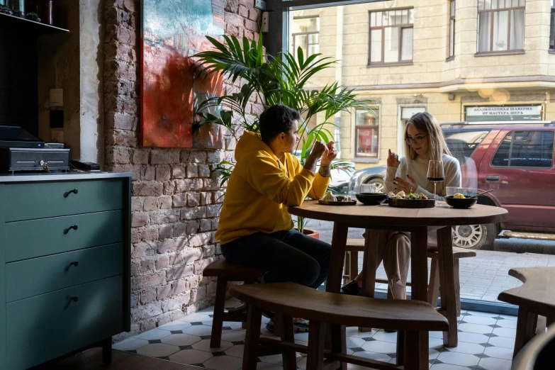 a couple of people that are sitting at a table, by Emma Andijewska, cozy environment, helsinki, sofya emelenko, russian