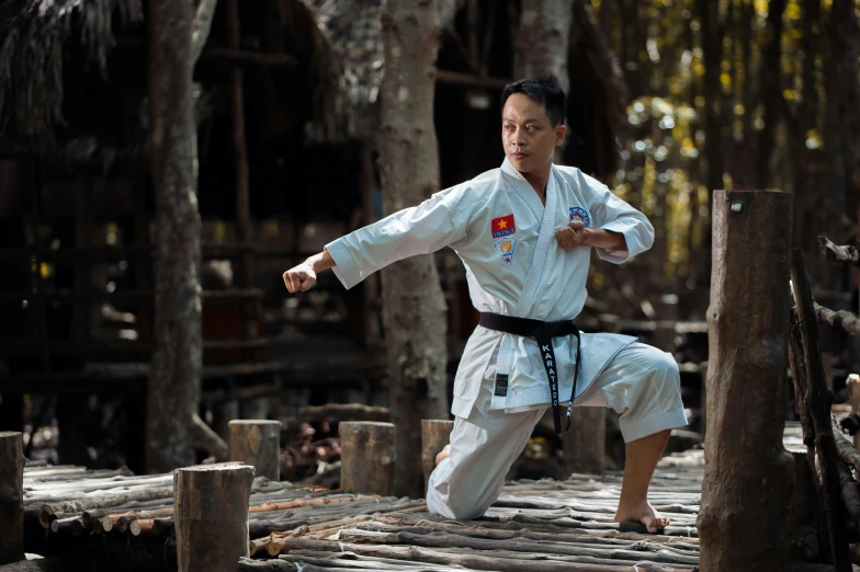 a man is practicing karate in the woods, a portrait, pexels contest winner, avatar image, cambodia, wearing authentic attire, 40 years old women