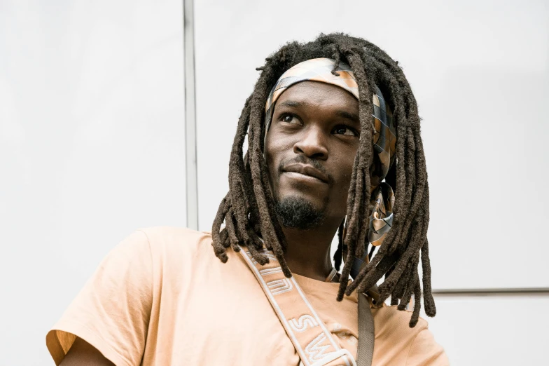 an image of a man with dreadlocks looking off to the side