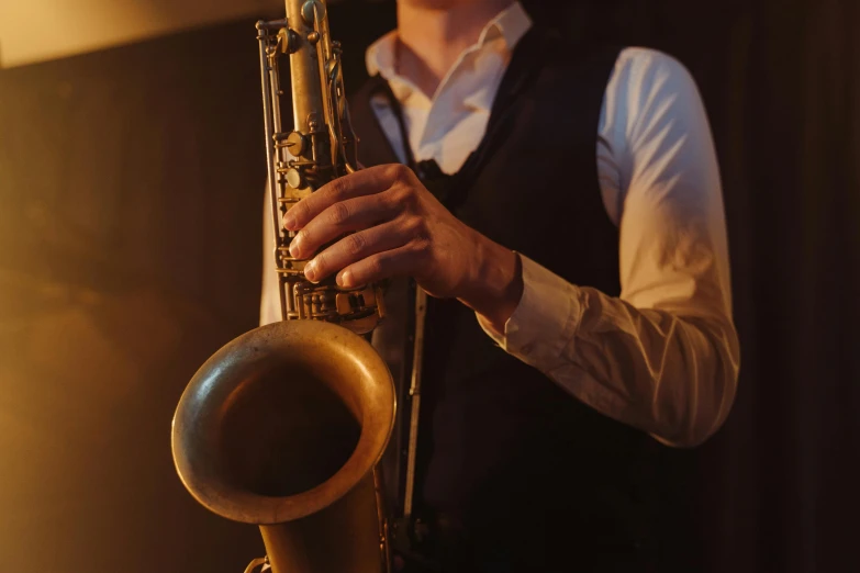 a man holding a trumpet while wearing a white shirt