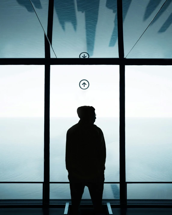 a silhouette of a man standing in front of a window, an album cover, pexels contest winner, postminimalism, observation deck, male with halo, tourist photo, black. airports
