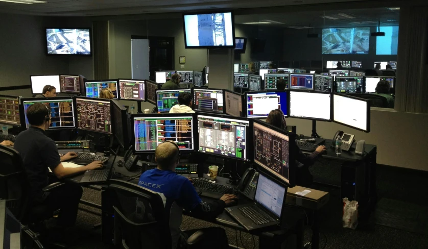 a group of people sitting in front of multiple computer screens, nasa, automated defence platform, warpgate, thumbnail