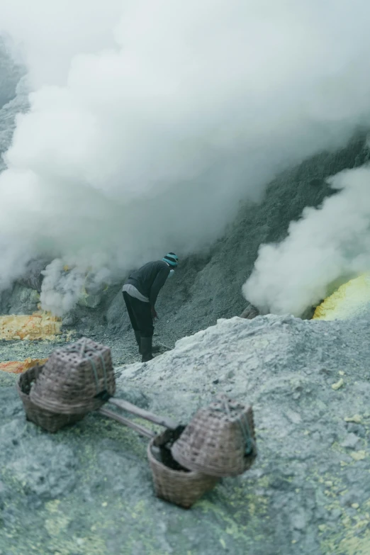 a man looking down at the clouds that are blowing up from an area