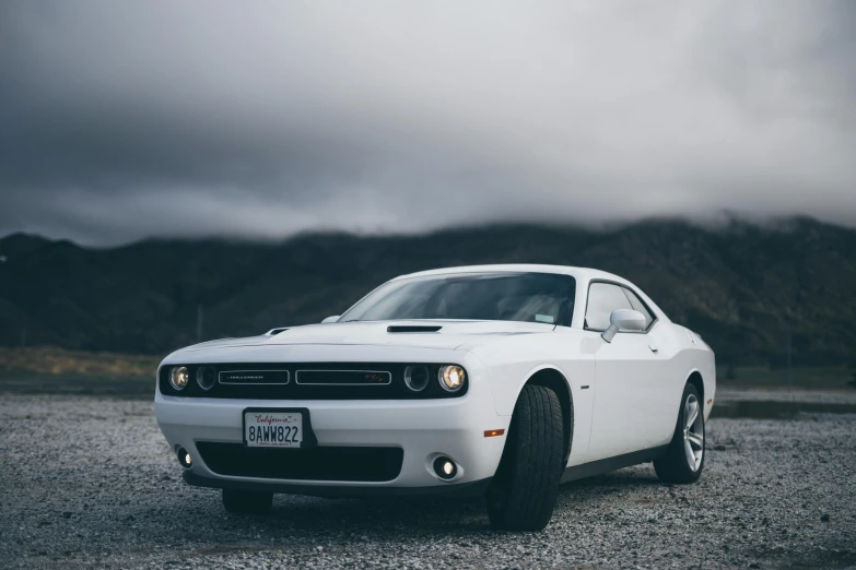 the front end of a white car parked in a parking lot