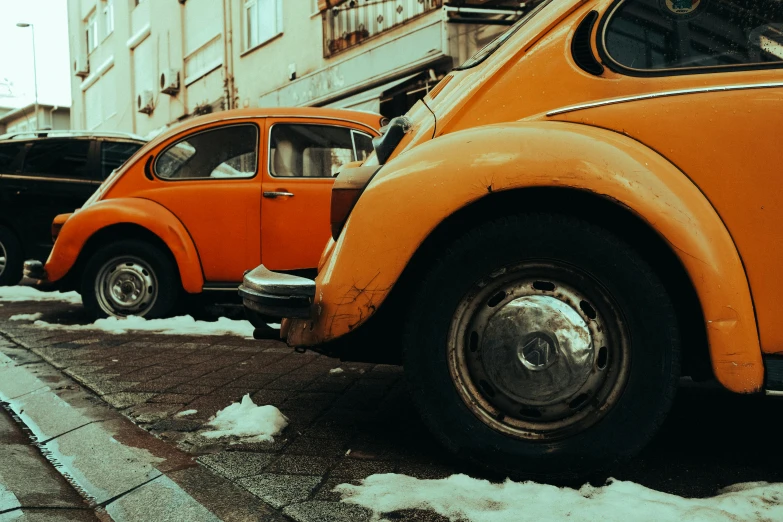 a couple of cars parked next to each other on the side of a road, a colorized photo, pexels contest winner, hyperrealism, beetles, orange and white, gritty image, 🚿🗝📝