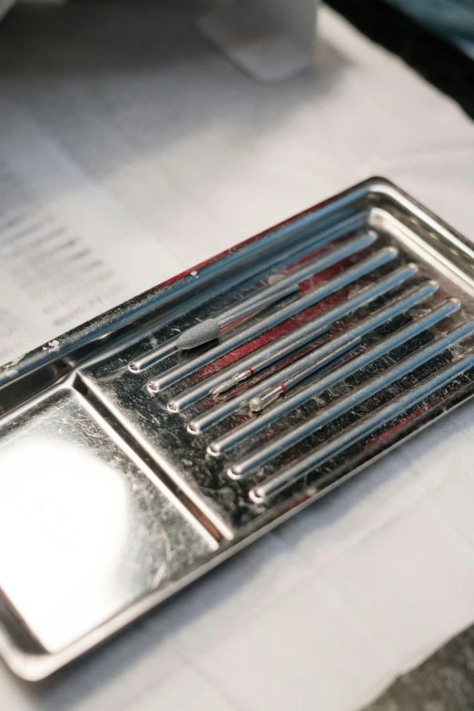 an empty metallic business card holder with several toothbrushes in it