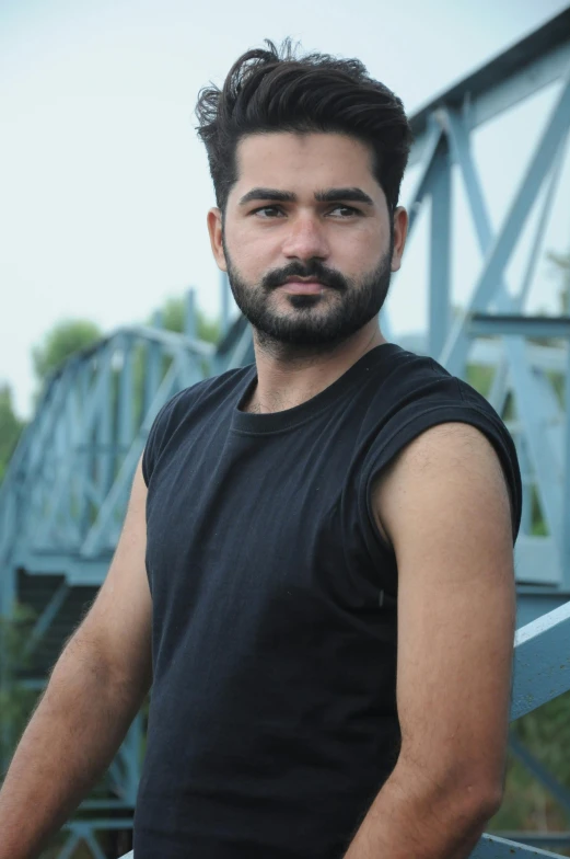 a man in black is standing by some metal structures