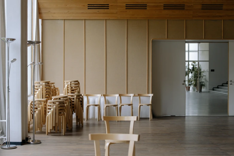 a group of chairs sitting against a wall next to a plant