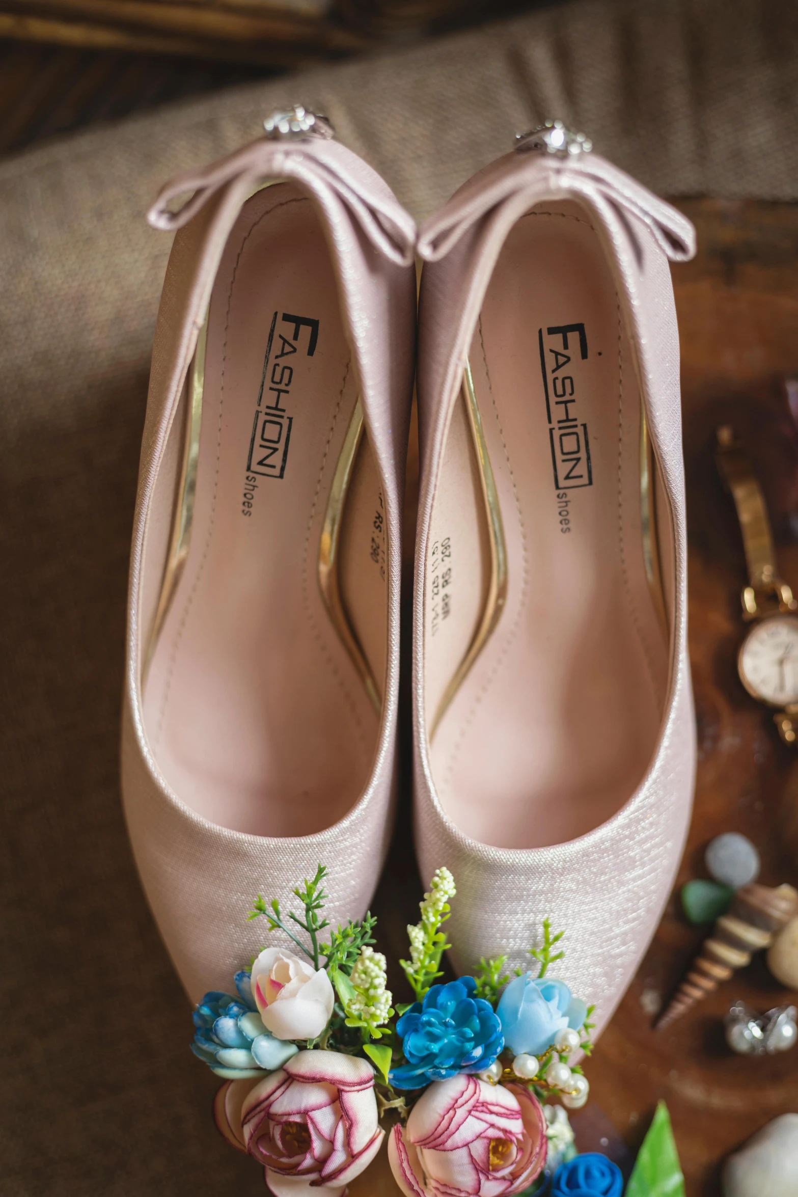 two pairs of pink high heeled shoes with floral bouquet