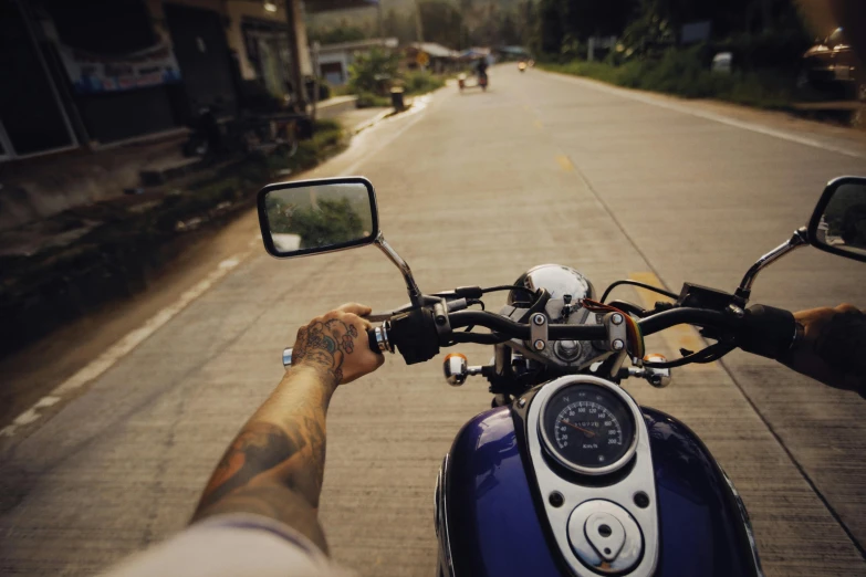 a person riding a motorcycle down a street, pexels contest winner, selfie, blue, open road, tattooed