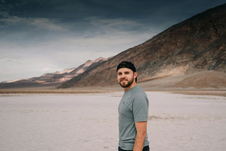 a man standing in the middle of a desert, a colorized photo, unsplash contest winner, rugged man portrait, with no beard, in mountains, avatar image