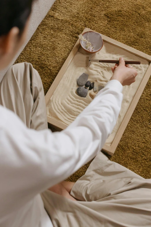 a person sitting on the floor holding a paddle