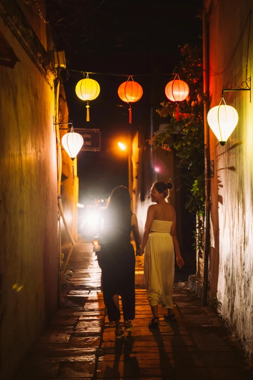 a couple of people walking down a narrow alley way